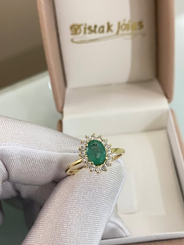 Anel em ouro com pedra verde e pedras claras ao redor